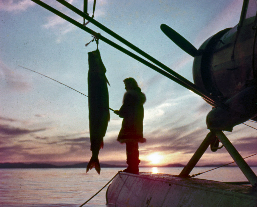 Woman fishing from the float of a small plane. Kotzebue.