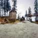 1960s Gary Bringing in a load of wood with our snow traveler. Outhouse in background.