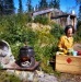 1969 Dorene cooking breakfast. Outdoor stove in front of our house. Using Blazo box as a table.