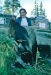 1964. Dora Douglas Dora by the fire pit with an untanned moose skin, Ambler, Alaska,