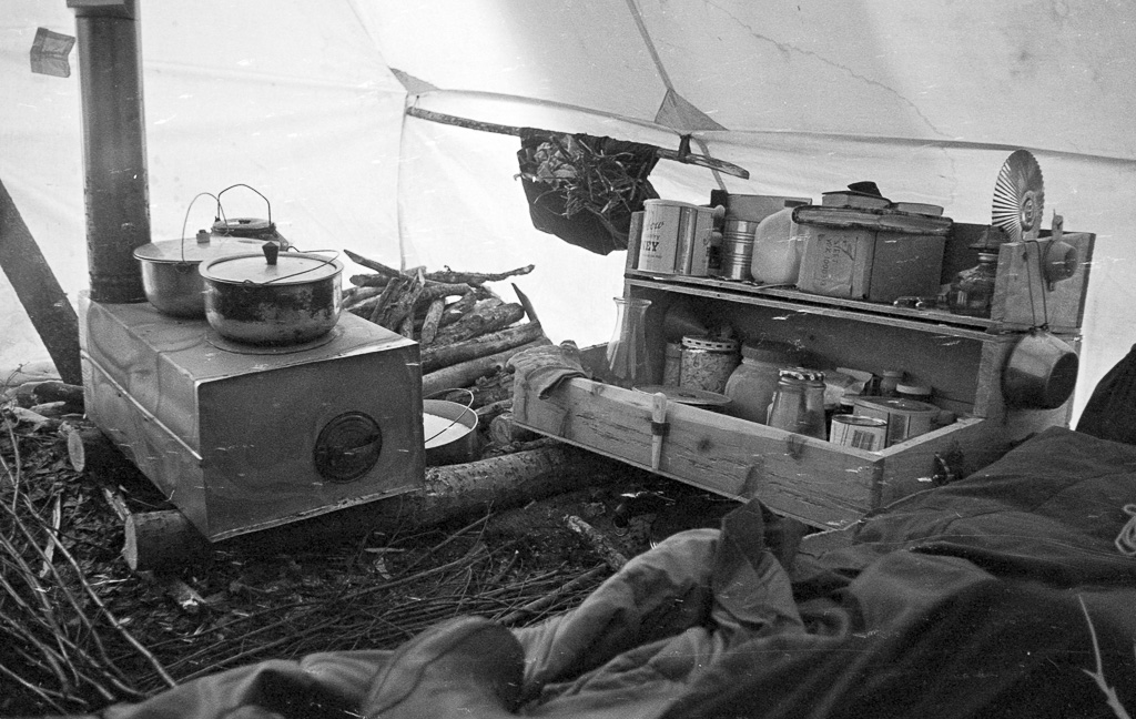 Oliver's wood stove in tent, grub box. Manley