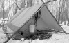 Olivers-tent-with-firewood-stacked-behind-along-with-dog-harnesses