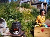 1969 Dorene cooking breakfast. Outdoor stove in front of our house. Using Blazo box as a table.