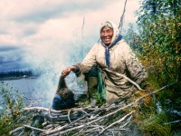 Maude Cleveland bruning the quills of of a porcupine before skinning it to cook.